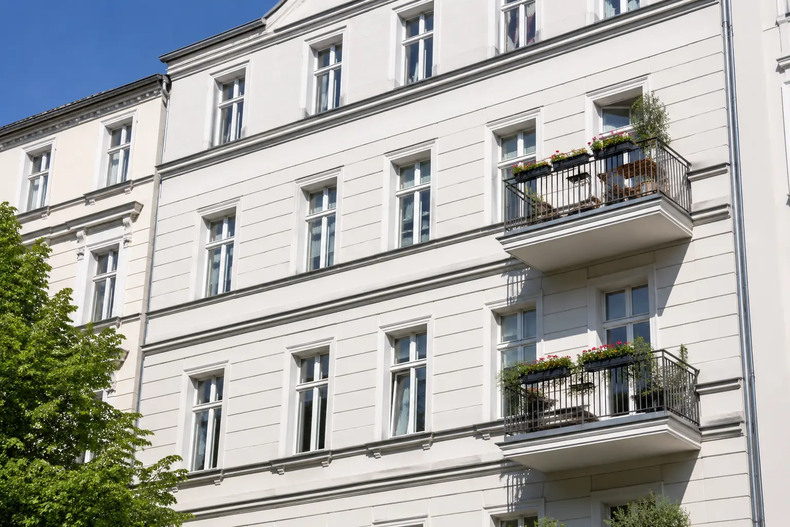 Gereinigte helle Altbaufassade mit Balkonen
